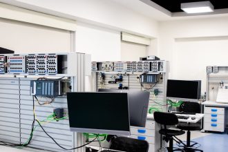 Laboratório de informática com estações de trabalho e equipamentos eletrônicos avançados para pesquisa e desenvolvimento.