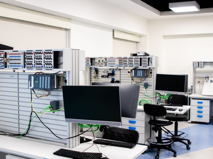 Laboratório de informática com estações de trabalho e equipamentos eletrônicos avançados para pesquisa e desenvolvimento.